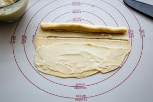 Hefe-Kringel Teig ausgerollt mit Vanillepudding bestrichen